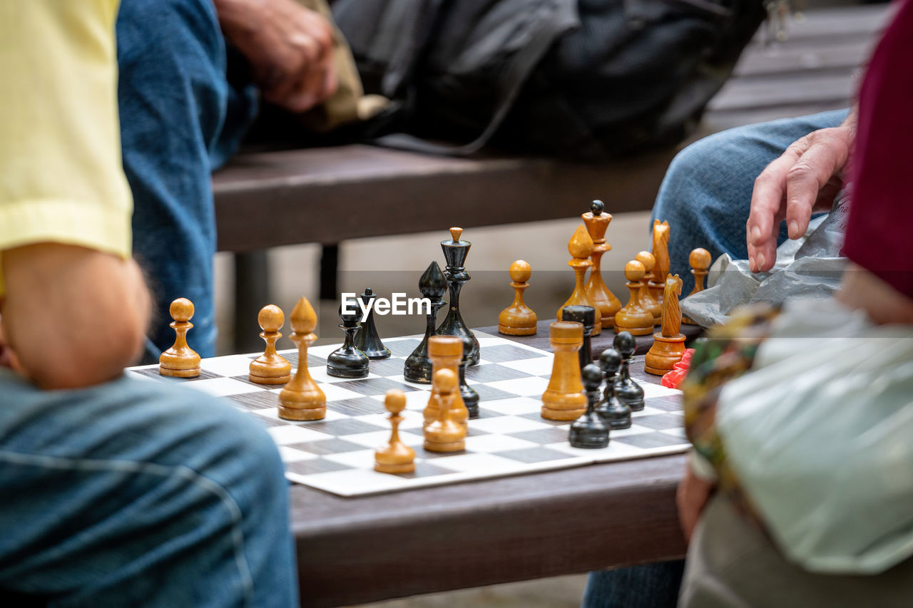 Midsection of men playing chess on board