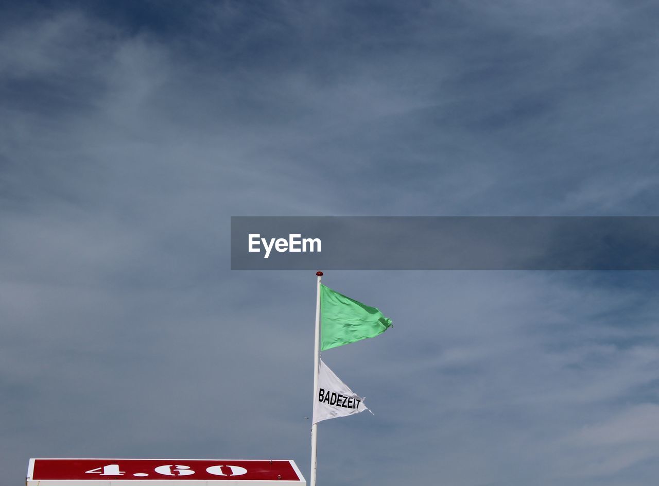 LOW ANGLE VIEW OF FLAG SIGN AGAINST SKY