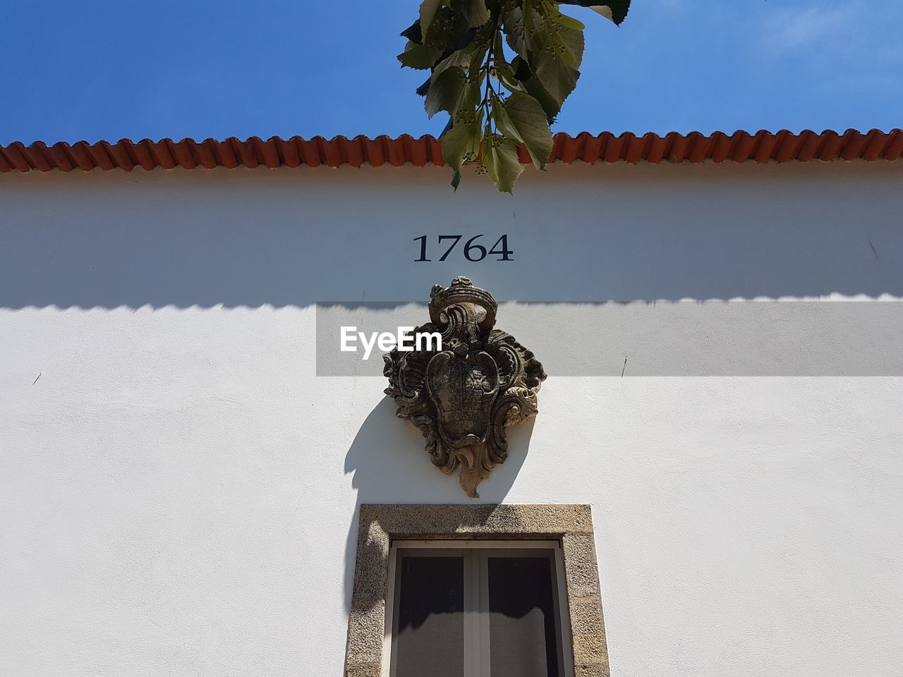 LOW ANGLE VIEW OF STATUE BY BUILDING AGAINST SKY