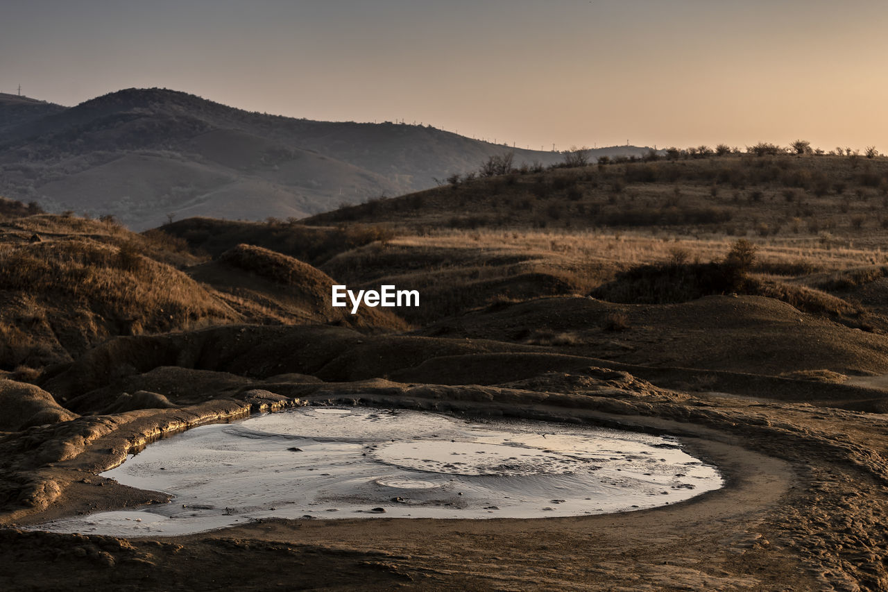 Mud volcano in autumn at sunset.