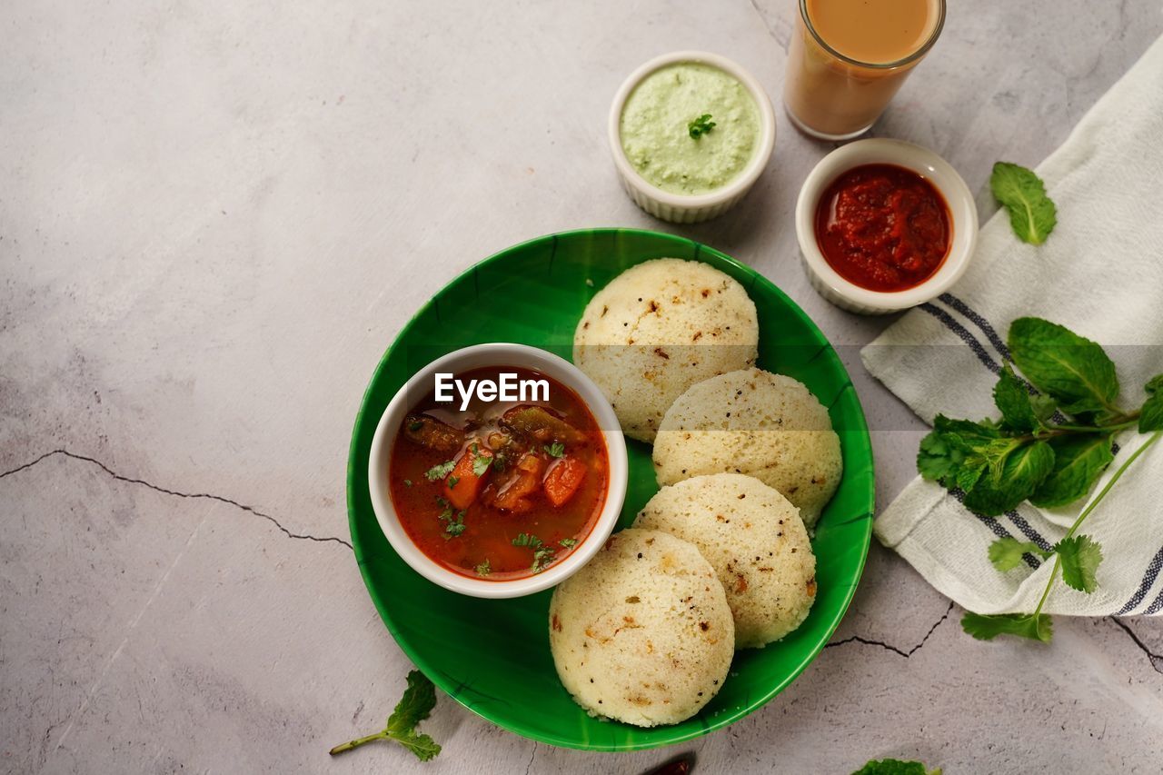 Rava idlis with sambar chutney and tea - south indian breakfast top down view