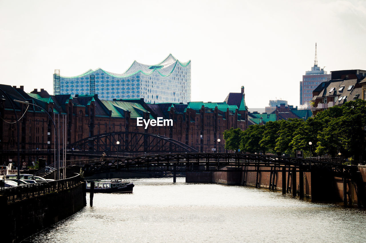 VIEW OF BRIDGE OVER RIVER AGAINST BUILDINGS