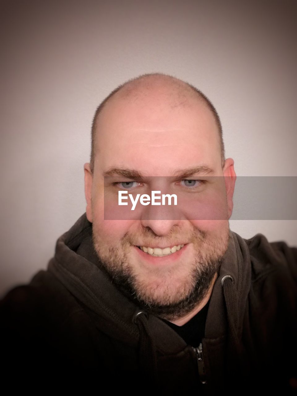 Close-up portrait of smiling man against wall