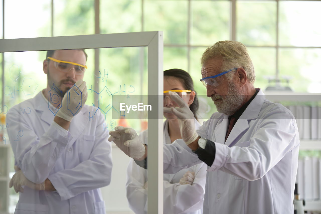 Scientist discussing formula while standing in laboratory