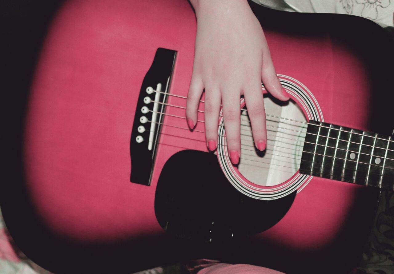 CLOSE-UP OF HAND PLAYING GUITAR IN THE DARK