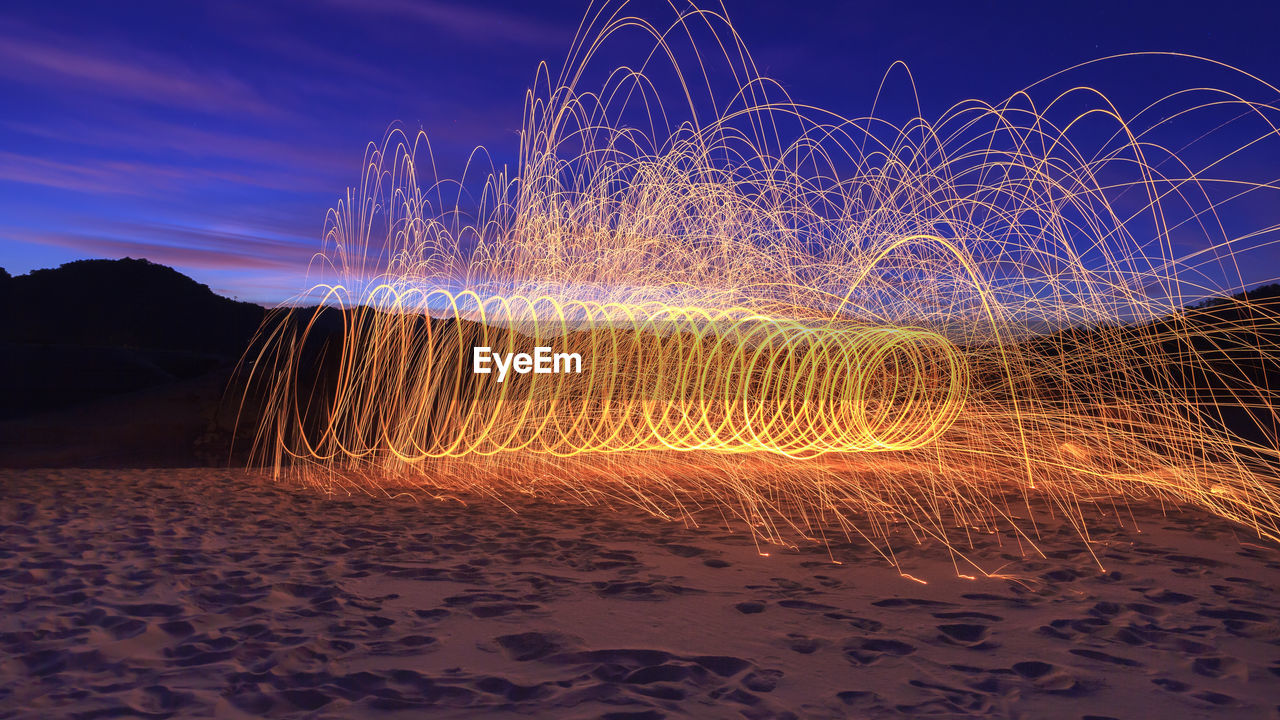 Wire wool on landscape against sky