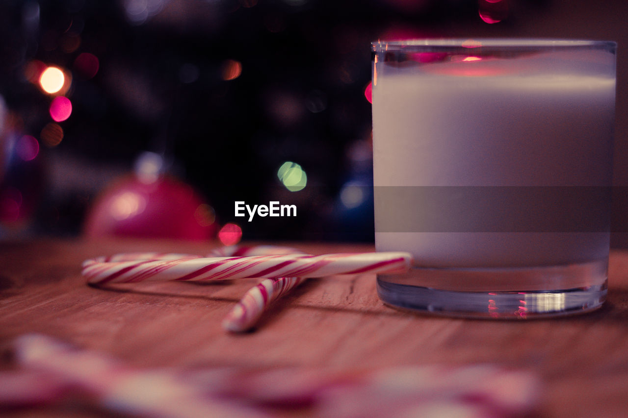 Close-up of drink by candy canes in glass on table