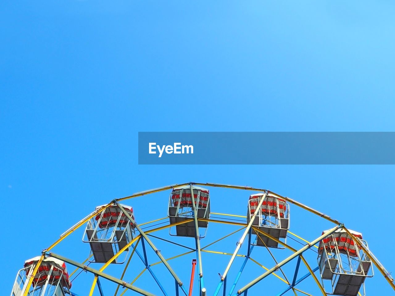 High section of ferris wheel against clear blue sky