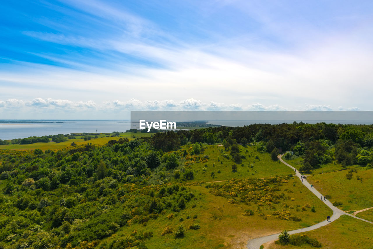 Scenic view of landscape by sea against sky