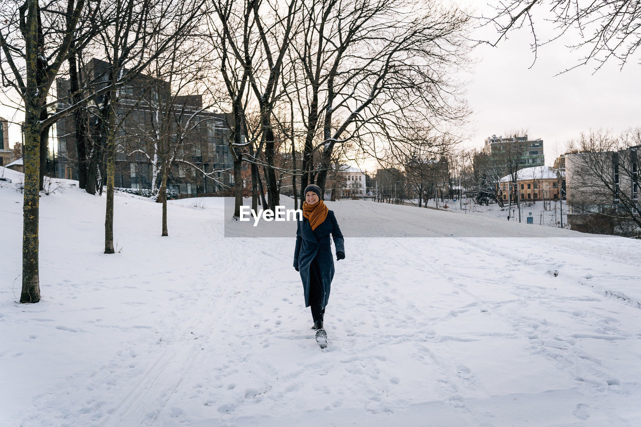 Wide viewing angle on a woman walking through a snowy winter city