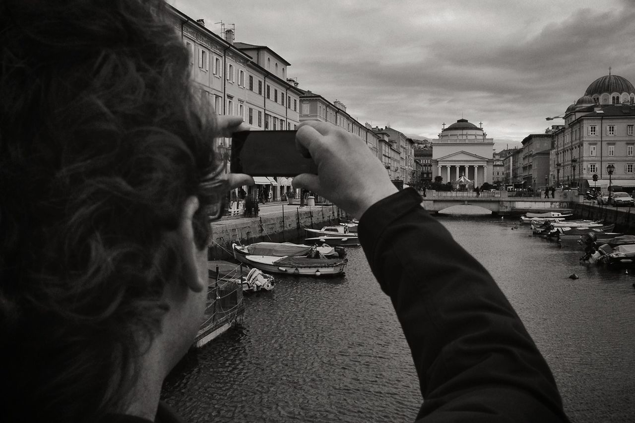 Man photographing river in city