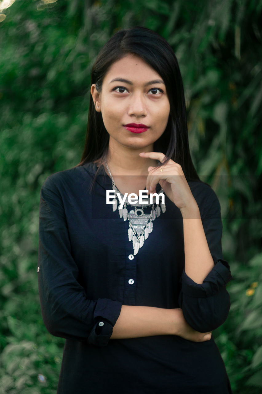 Portrait of young woman standing on field