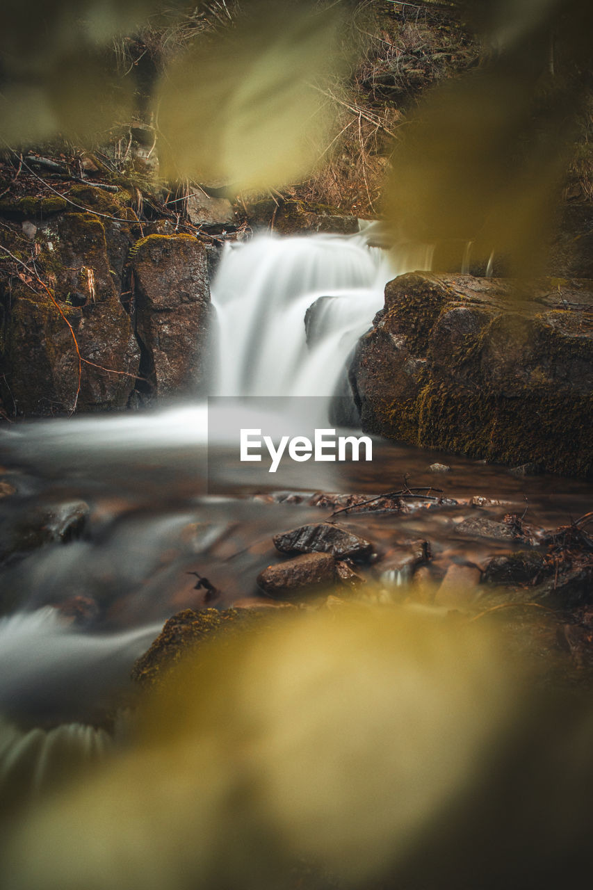 waterfall, nature, water, scenics - nature, environment, beauty in nature, long exposure, motion, reflection, autumn, forest, land, flowing water, blurred motion, tree, flowing, landscape, rock, river, body of water, stream, morning, plant, no people, water feature, sunlight, travel destinations, outdoors, fog, speed, darkness, travel, leaf, environmental conservation, power in nature, tourism, social issues