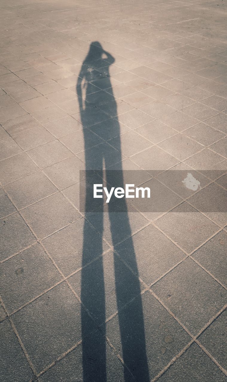 LOW SECTION OF MAN STANDING ON SHADOW OF PERSON