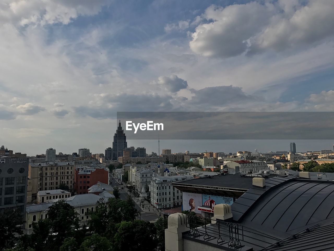 HIGH ANGLE VIEW OF BUILDINGS IN CITY AGAINST CLOUDY SKY