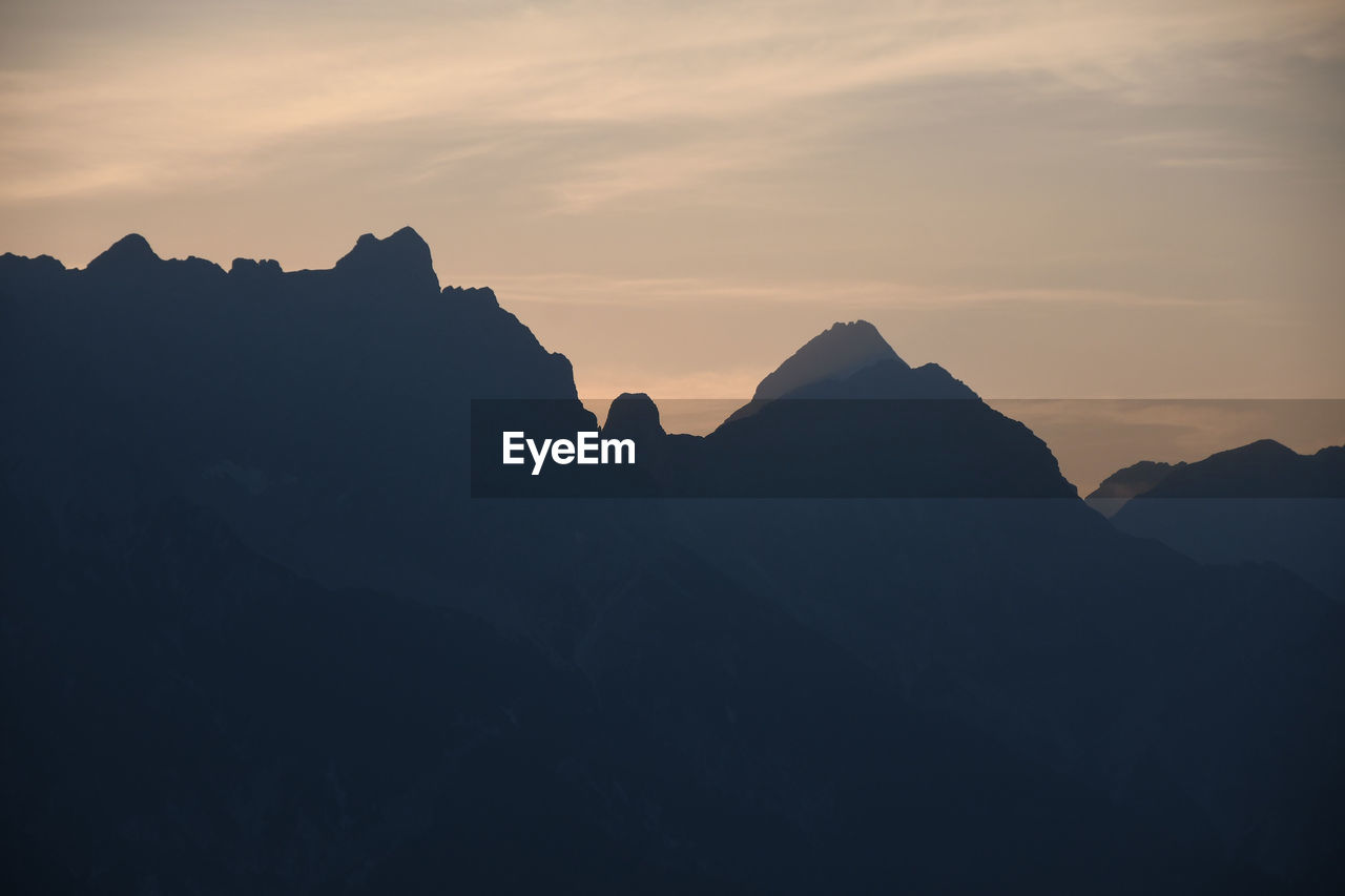 Mountains silhouette with peaks in the morning mist saalfelden, salzburg, austria