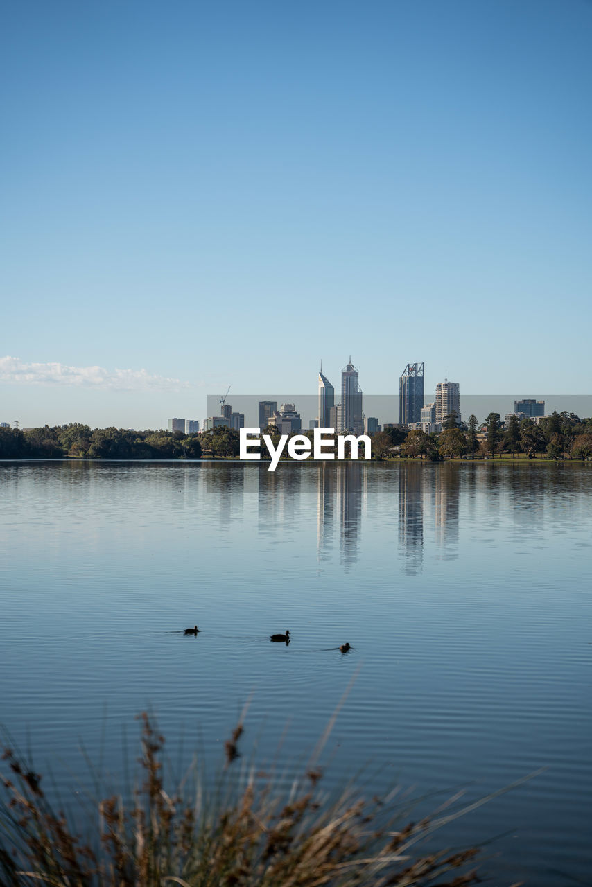 SCENIC VIEW OF LAKE BY BUILDINGS AGAINST SKY
