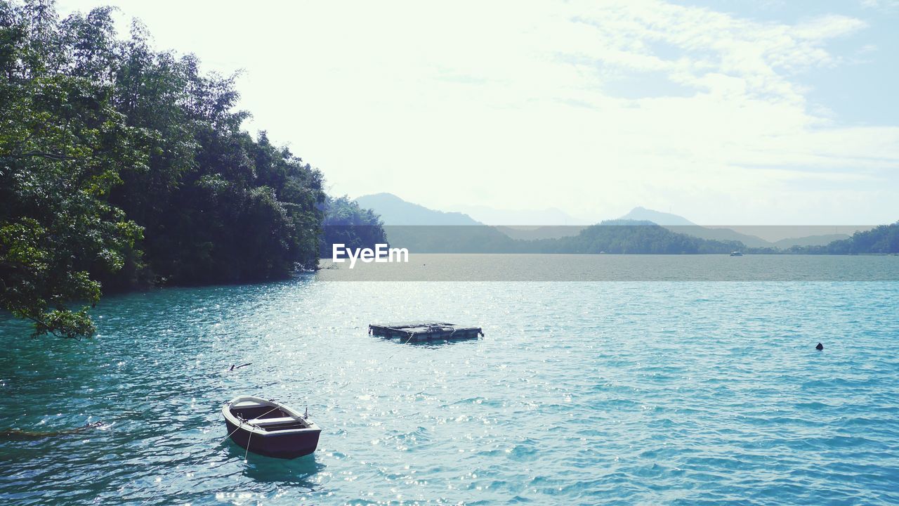 SCENIC VIEW OF LAKE BY MOUNTAIN AGAINST SKY