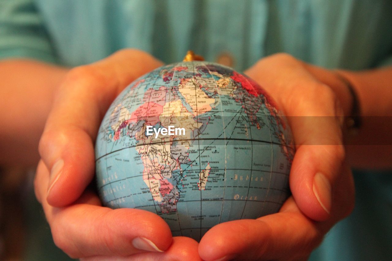 Midsection of woman holding globe