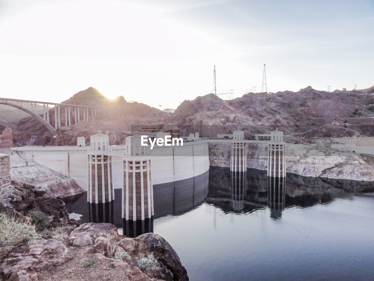 Built structure by river against sky