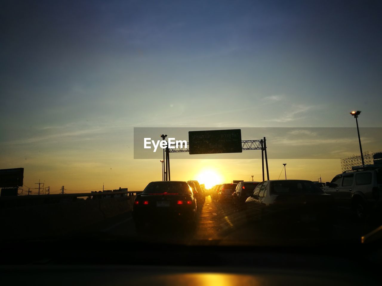 SILHOUETTE CARS ON ROAD AGAINST SKY DURING SUNSET