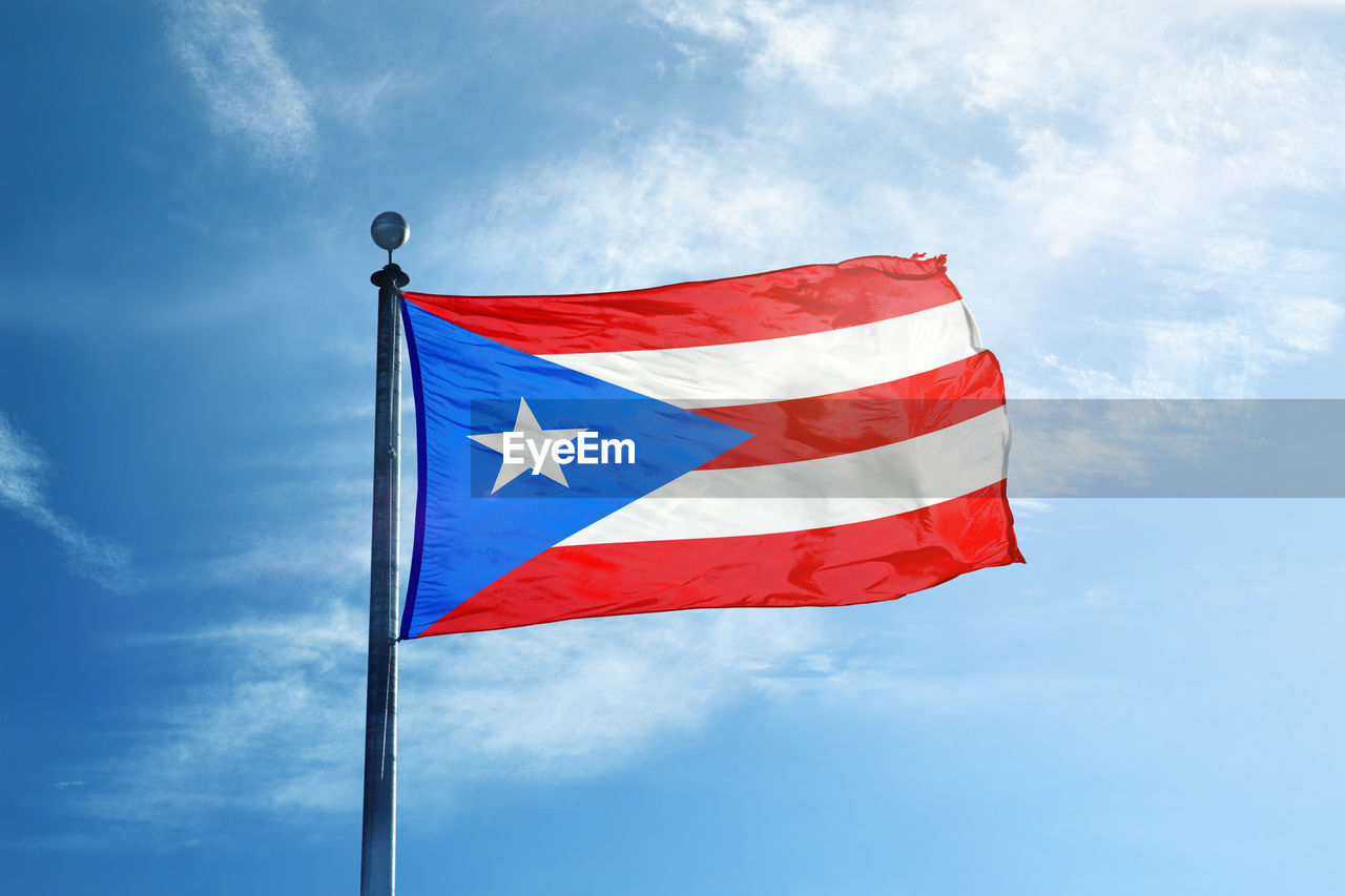 LOW ANGLE VIEW OF FLAGS AGAINST BLUE SKY