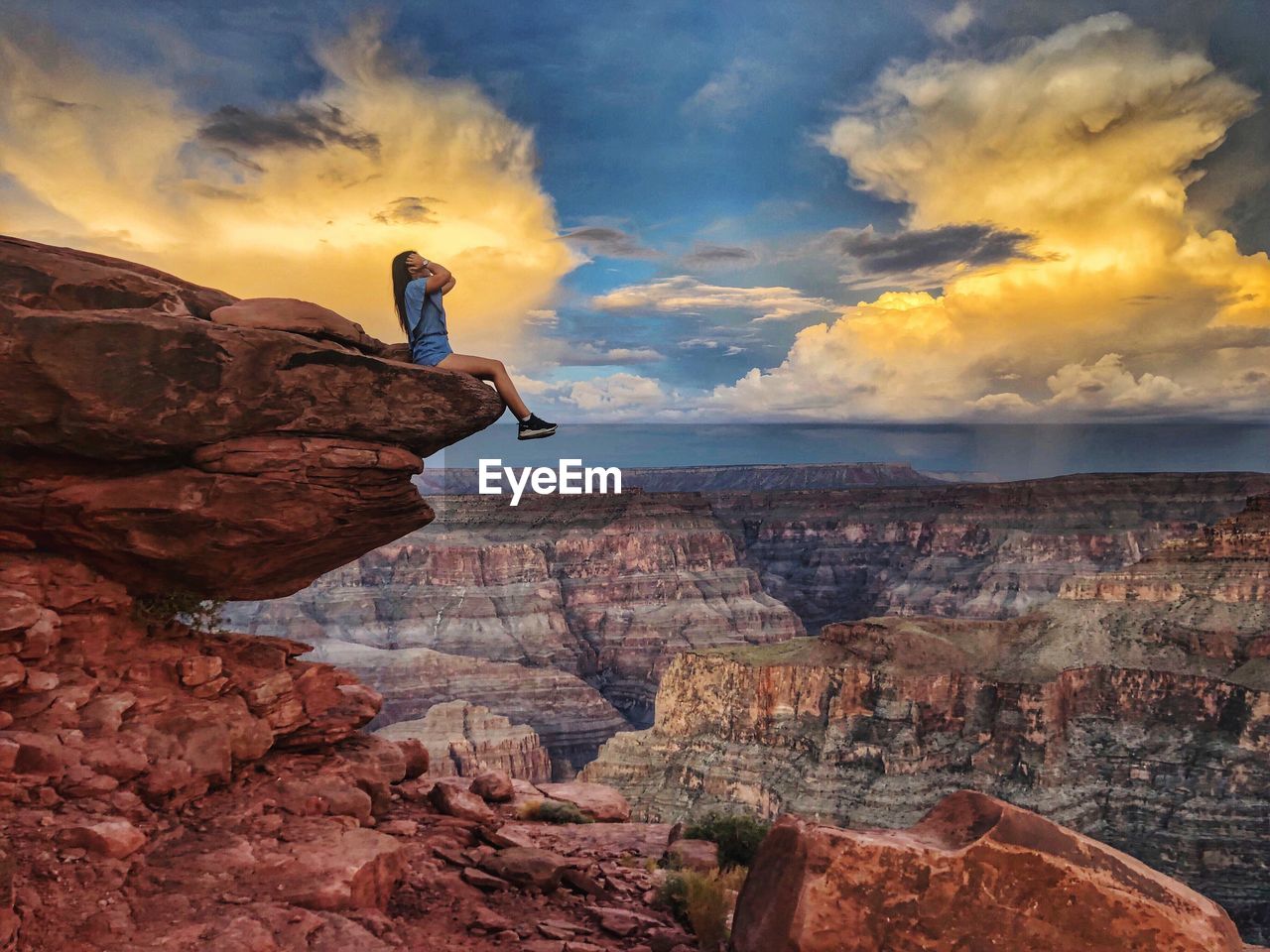 MAN ON ROCK FORMATIONS AGAINST SKY