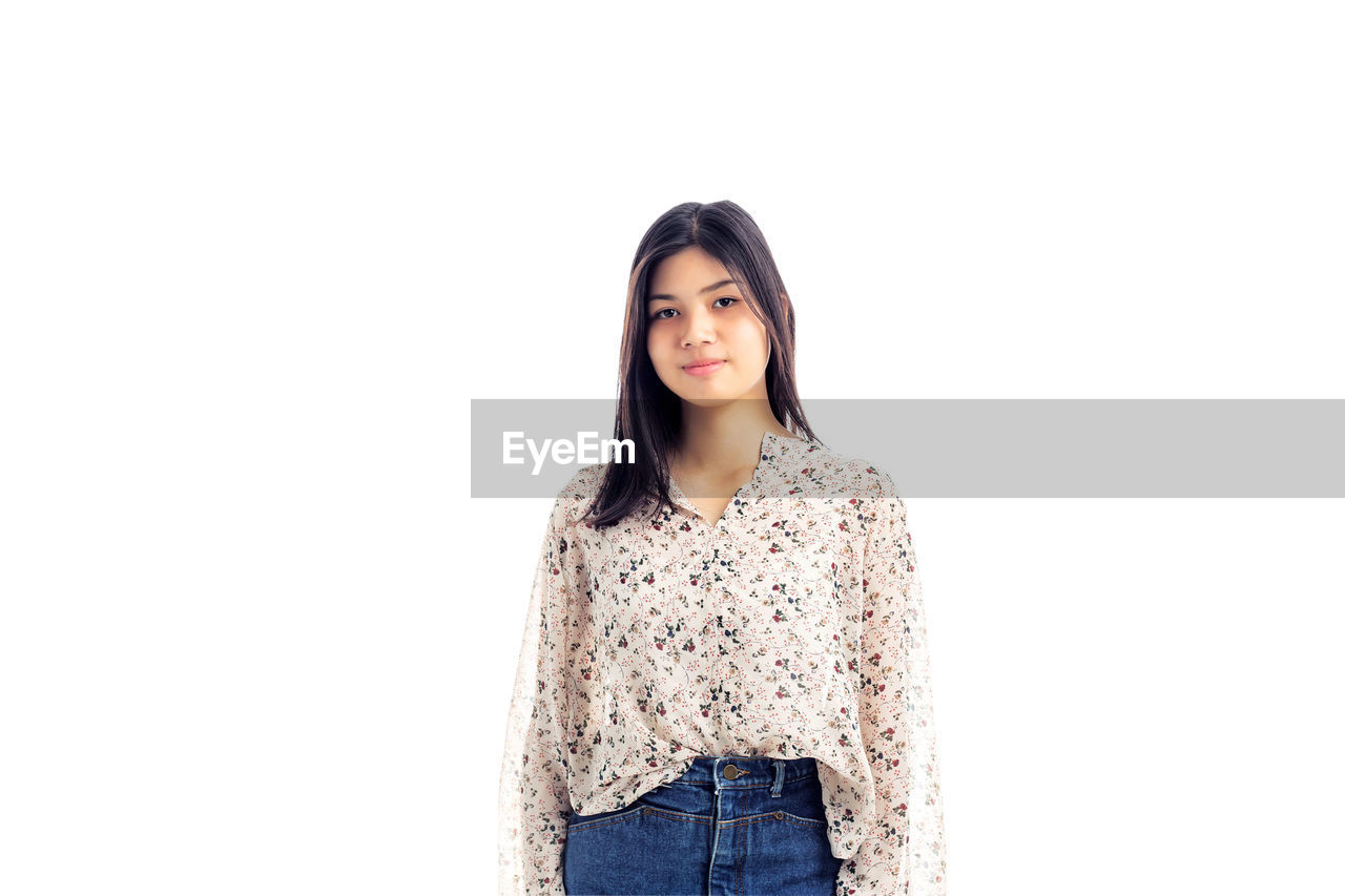 PORTRAIT OF A BEAUTIFUL YOUNG WOMAN AGAINST WHITE BACKGROUND