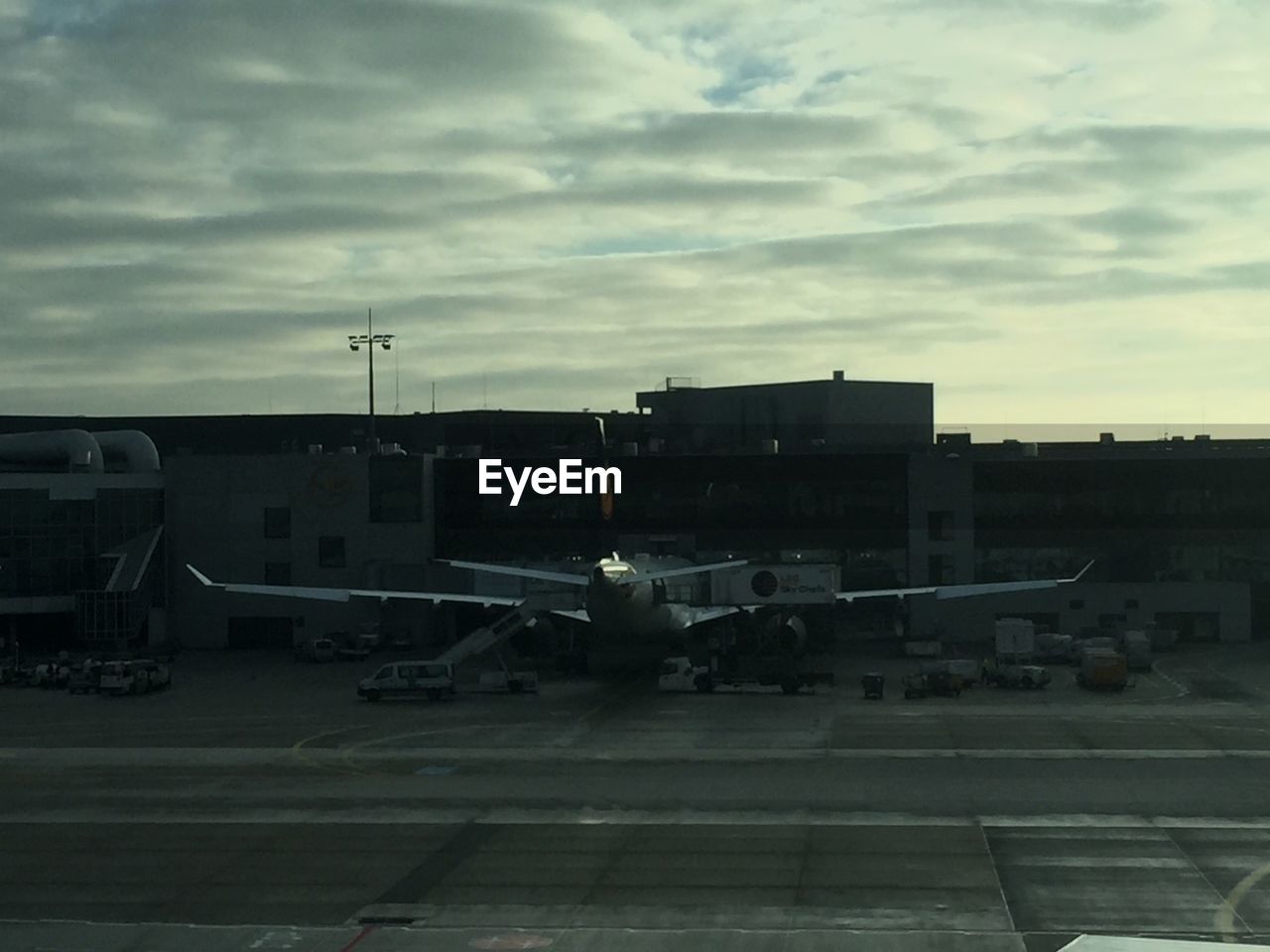 Airplane on runway at frankfurt airport against cloudy sky