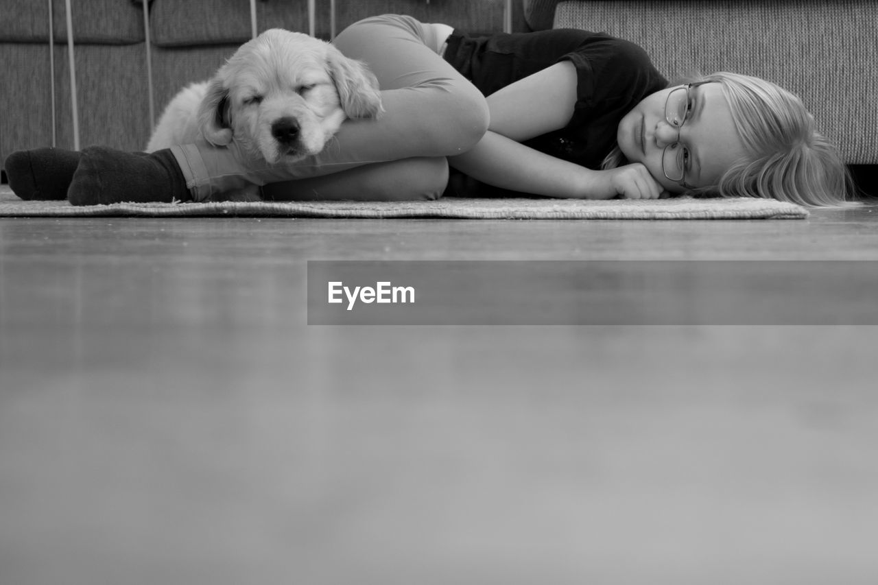Girl and dog resting on floor at home