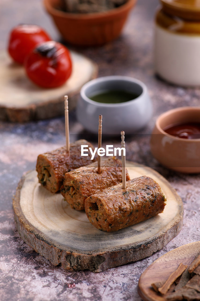 Indian food chicken seekh kebab on a wooden platter with sauce