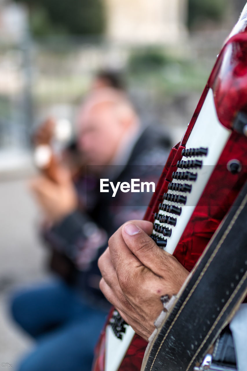 Midsection of man playing musical instrument