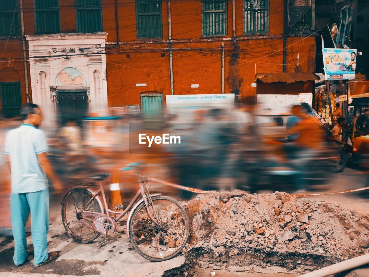 rear view of man riding bicycle on street in city