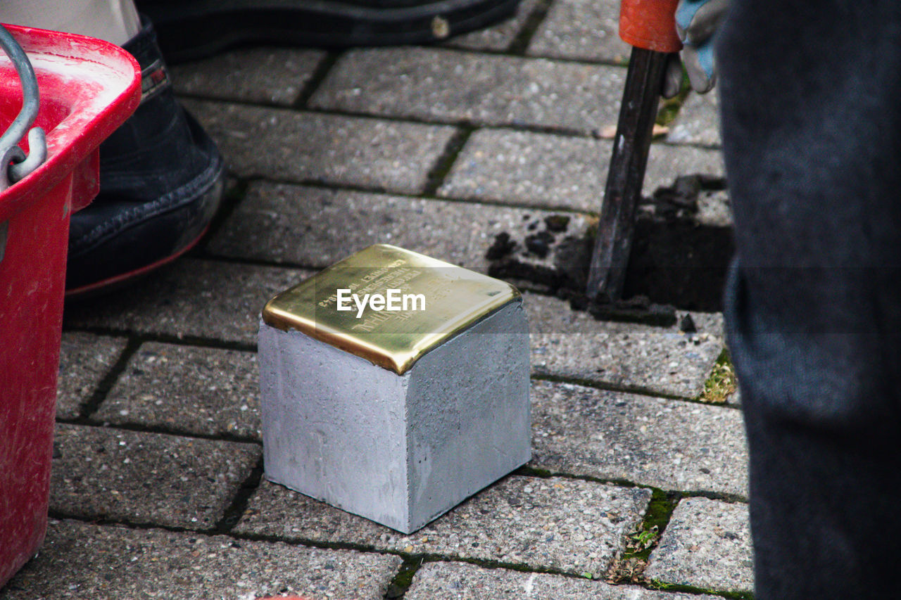 HIGH ANGLE VIEW OF METAL ON SIDEWALK