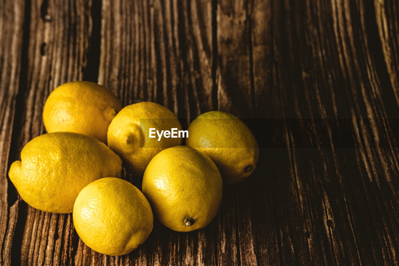 HIGH ANGLE VIEW OF ORANGES ON WOODEN TABLE