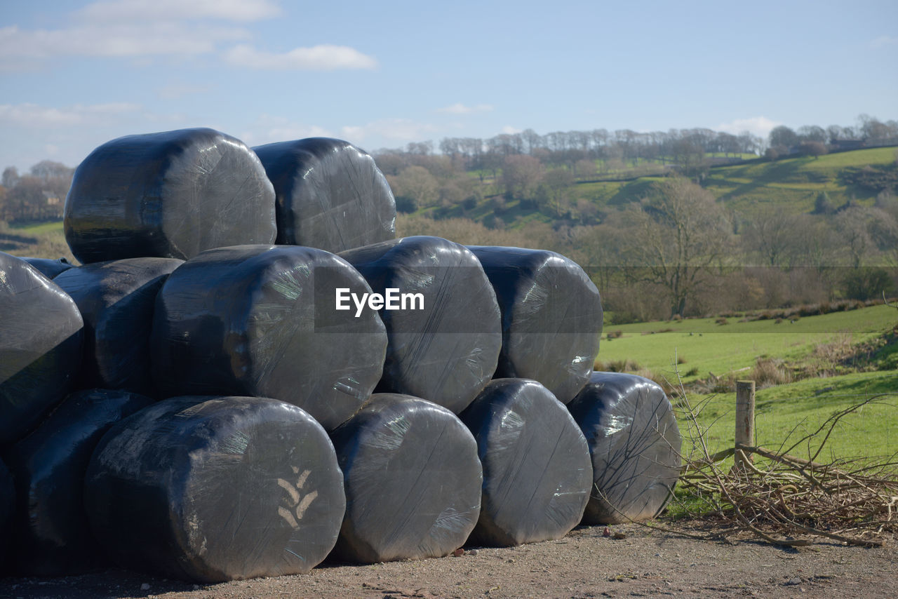 Stack of black plastic wrapped hay bales, also known as haylage, with copy space to the right