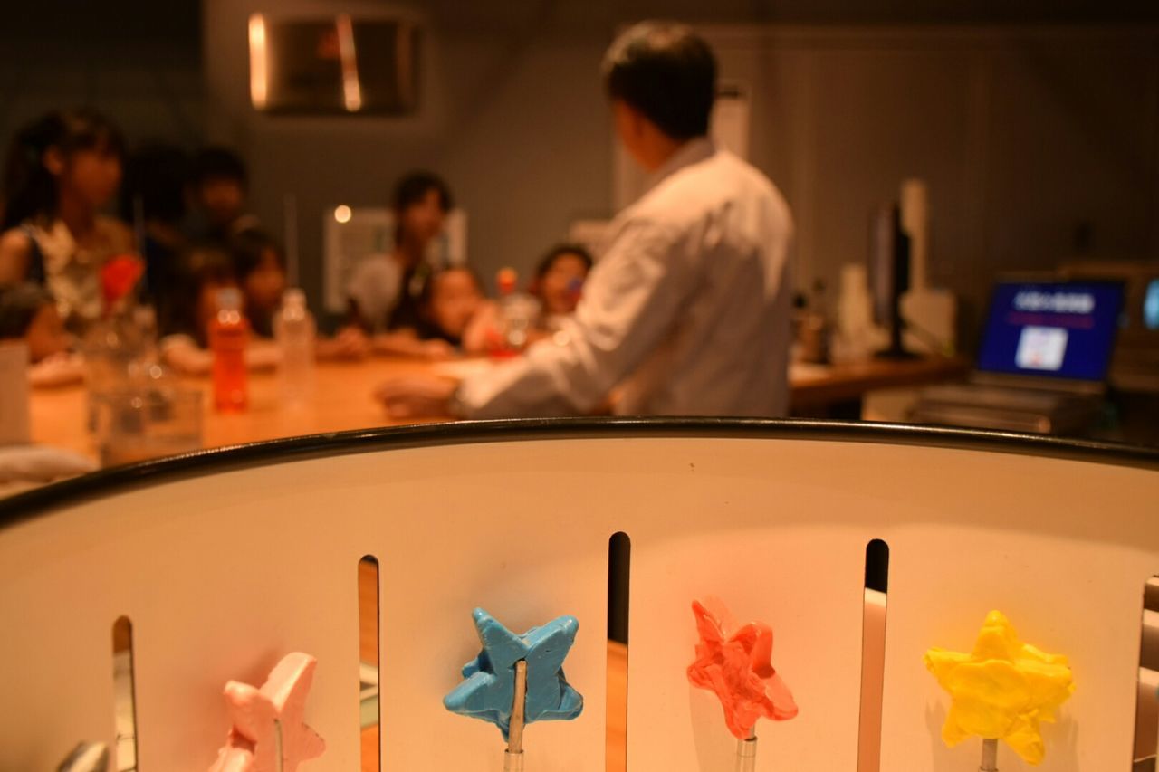 Close-up of candles with people in background at restaurant