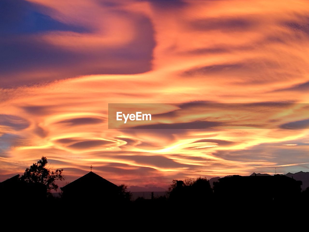 SILHOUETTE HOUSES AGAINST SKY AT SUNSET