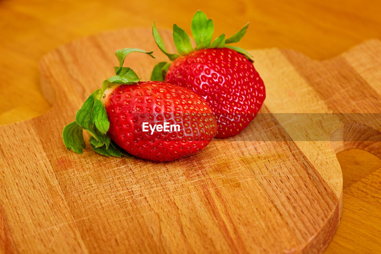 HIGH ANGLE VIEW OF STRAWBERRIES ON CUTTING BOARD