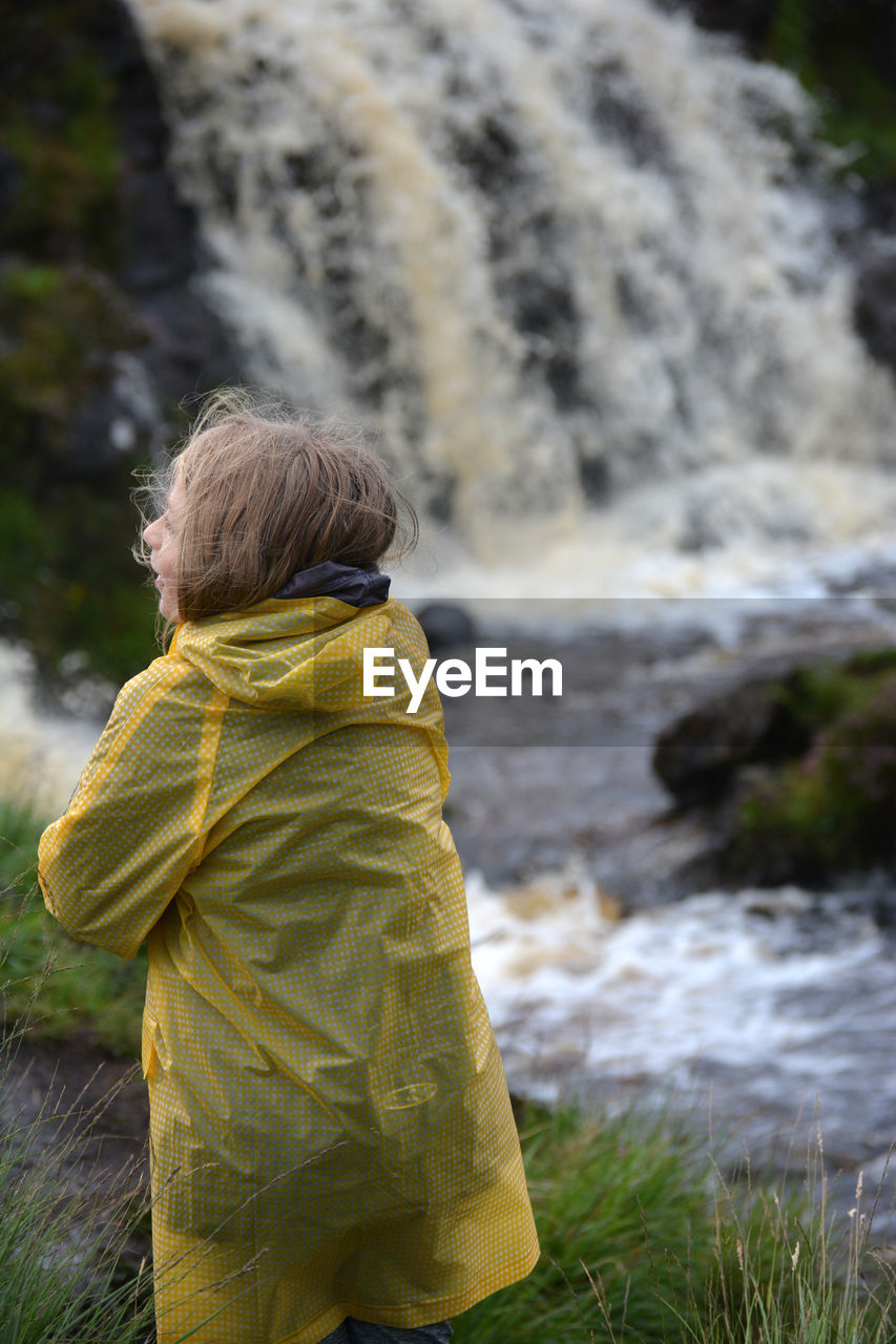 Rear view of woman looking at waterfall