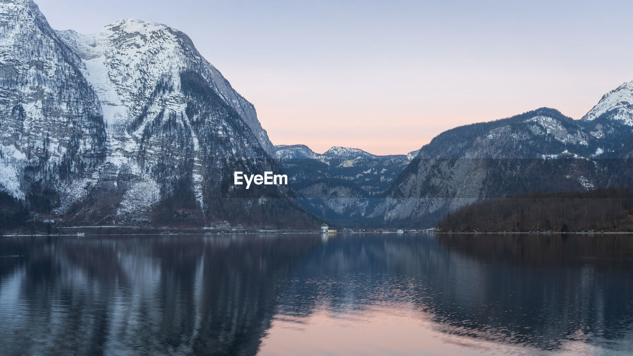 Beautiful alpine lake reflecting surrounding peaks during sunrise, narrow shot, austria, europe