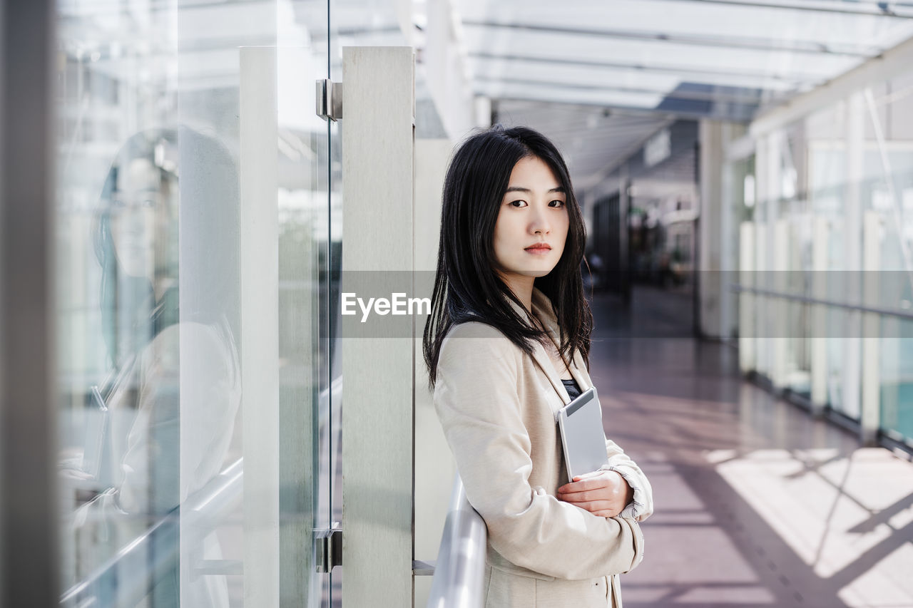 Portrait of beautiful chinese business woman using digital tablet in building office. technology