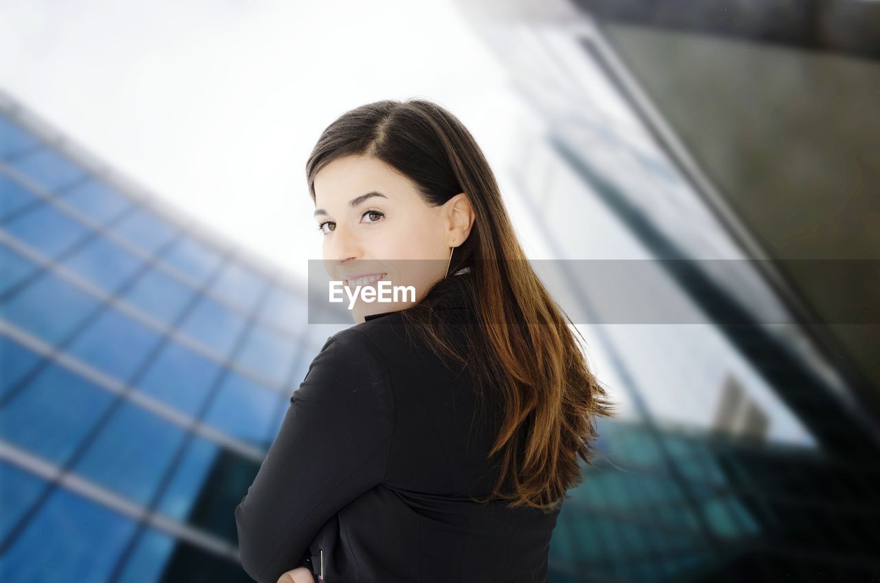 Smiling businesswoman outside office building