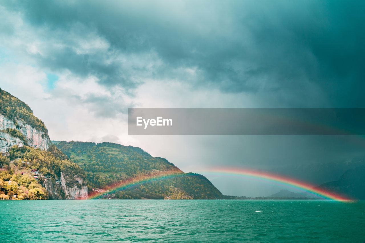 Scenic view of rainbow over sea against sky