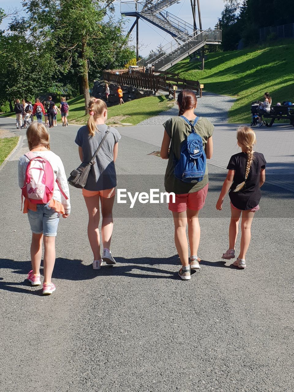 Rear view of people walking on road in city