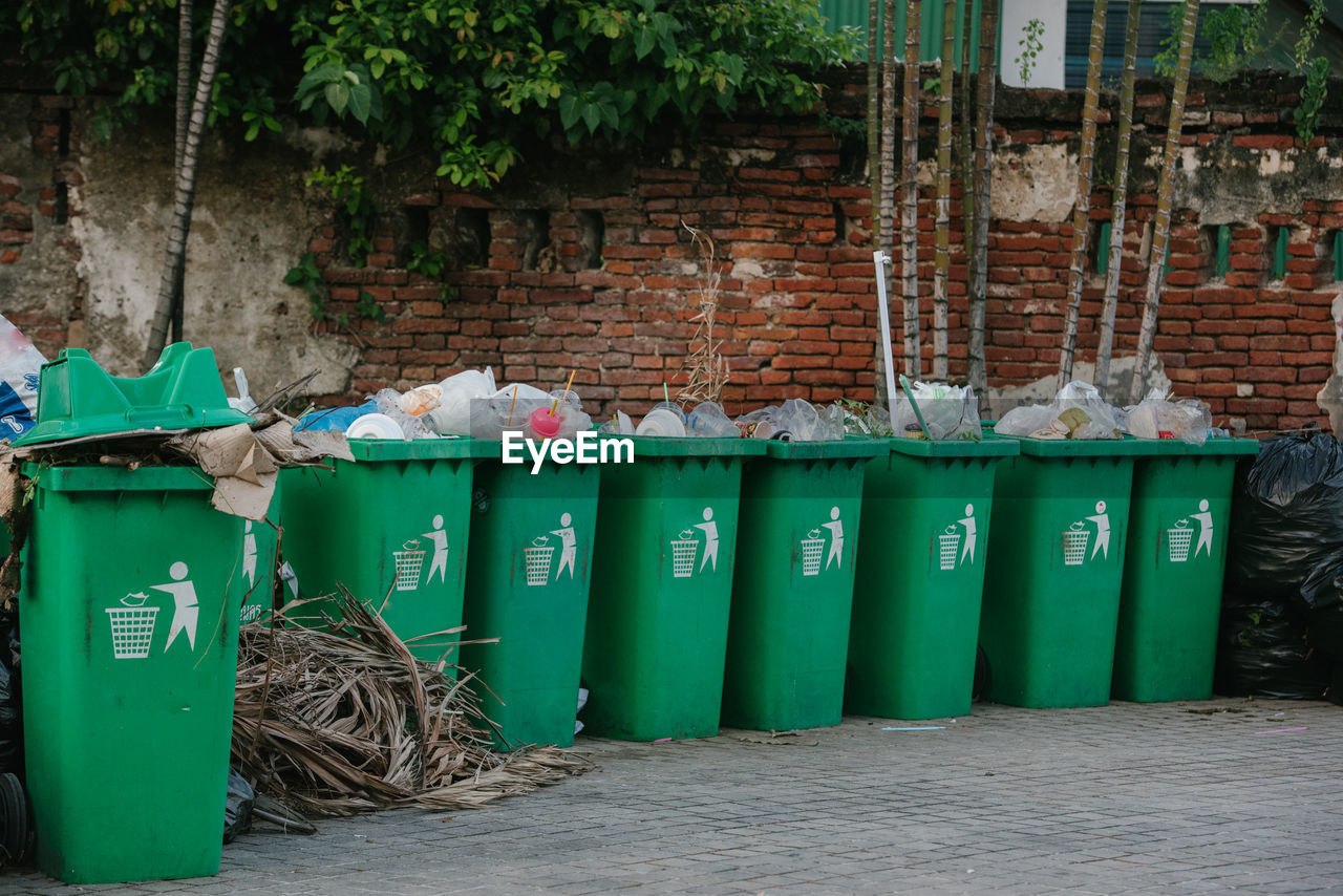 CLOSE-UP OF GARBAGE BIN AGAINST WALL