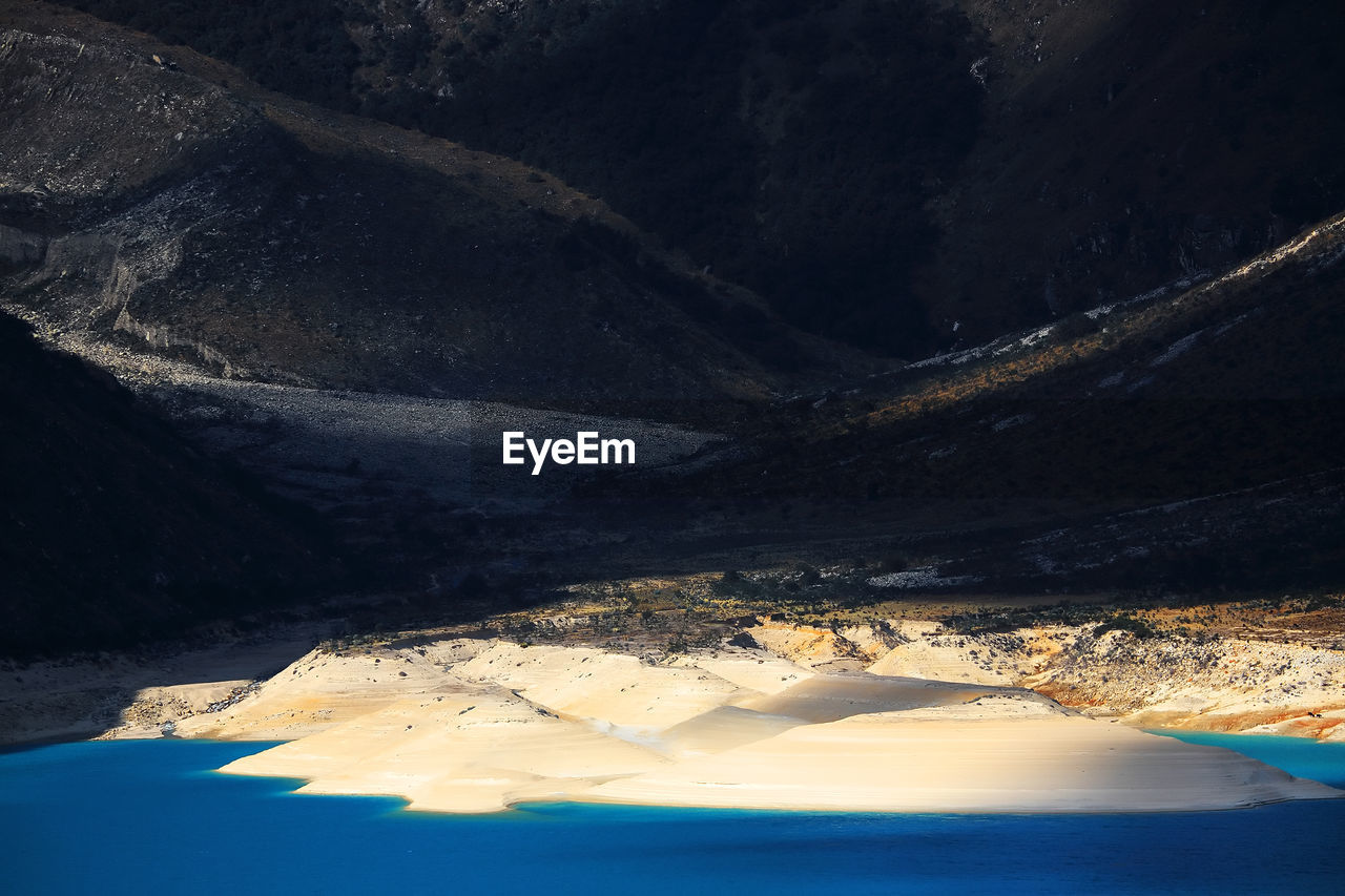 View of lakeshore against mountain