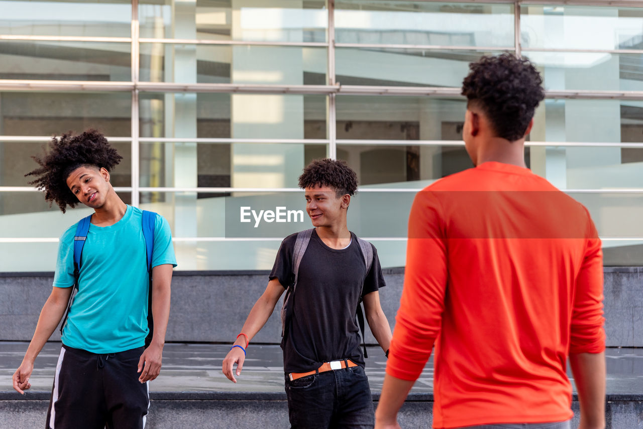 Young men standing against people