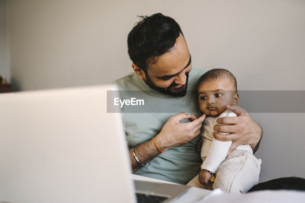 Father with baby working from home