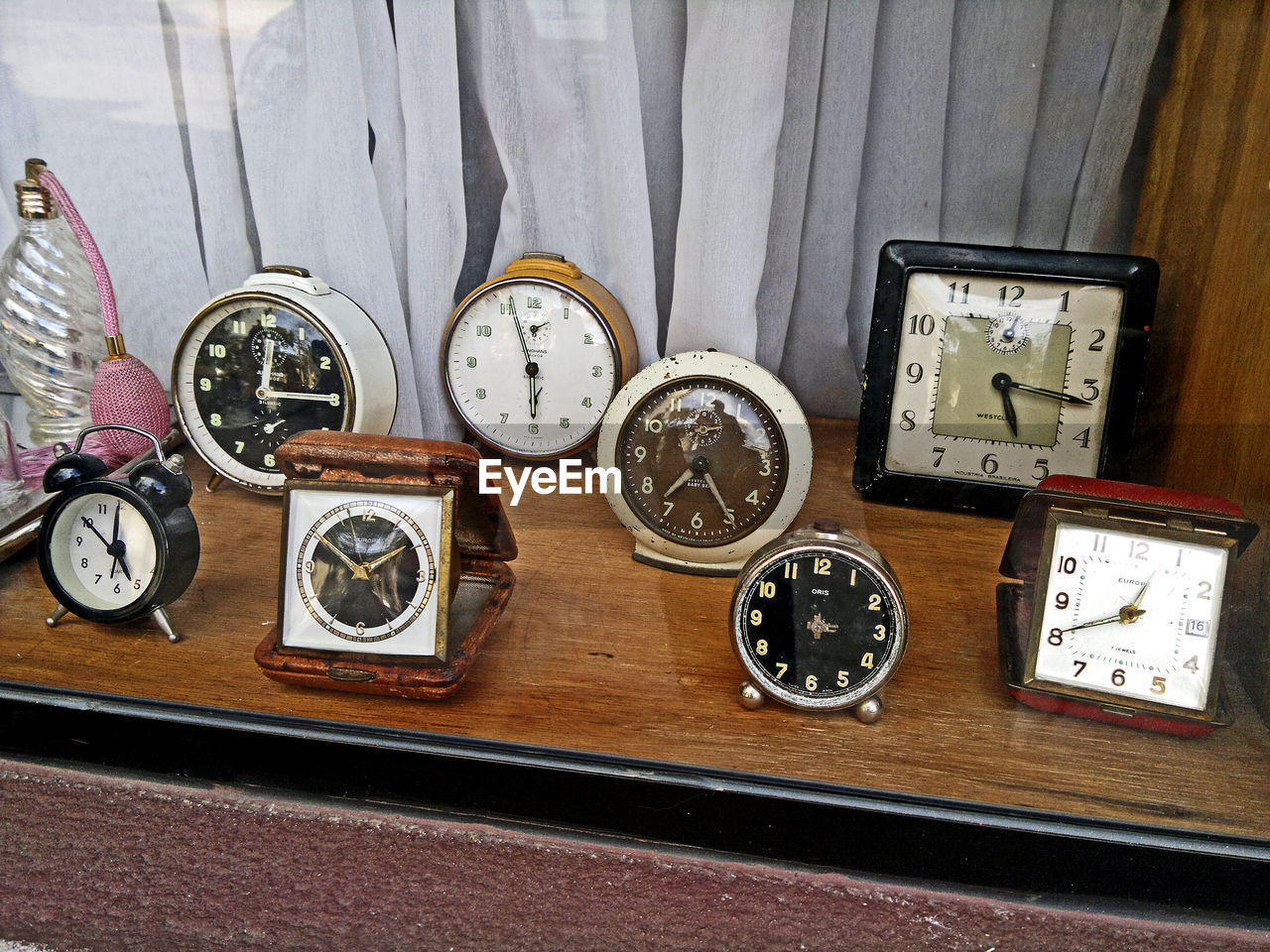 High angle view of vintage alarm clocks on table against curtain in store